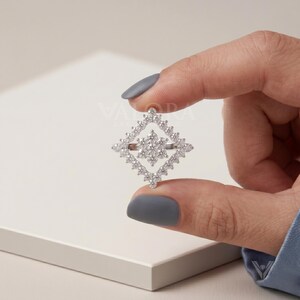 Captivating hand model lifestyle layout emphasizing a luxurious statement ring look for style buyers. This brilliant lab diamond custom piece showcases an elegant snowflake geometric open cluster shape. Features trendy jewelry aesthetics that complement upcoming winter seasonal holiday ring collection. Delivers a true to size premium luxury look while providing high sparkle fire radiance to consumers.