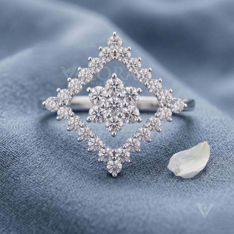 Front view studio shot of an art deco style ring featuring a custom 14k gold frame. The main stone shape is a geometric square halo holding an elegant lab diamond snowflake cluster. Crafted for modern brides seeking bespoke fine jewelry with a luxury look. Perfect sustainable diamond statement piece option for a unique wedding band look, showing incredible symmetry and craftsmanship in white tone.