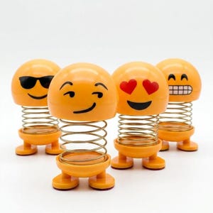 Peut inclure: Quatre figurines emoji jaunes à tête oscillante avec des ressorts métalliques. La première porte des lunettes de soleil noires, la deuxième fait un clin d'œil, la troisième a des yeux en forme de cœur et la quatrième une expression grimaçante.
