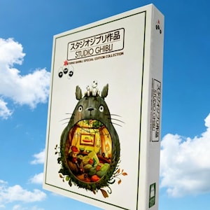 Pode incluir: Uma caixa branca da Studio Ghibli Special Edition Collection contra um c&eacute;u azul. A caixa apresenta uma grande ilustra&ccedil;&atilde;o de Totoro com uma cena interior detalhada. O texto japon&ecirc;s &eacute; vis&iacute;vel na parte superior e lateral da caixa, juntamente com pequenas ilustra&ccedil;&otilde;es de personagens.