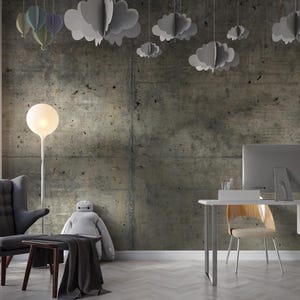 Peut inclure: Int&eacute;rieur de bureau moderne avec un mur en b&eacute;ton. Un fauteuil gris, une petite table en bois et un bureau avec un &eacute;cran d'ordinateur sont visibles. Des d&eacute;corations en forme de nuages et de ballons sont suspendues au plafond.