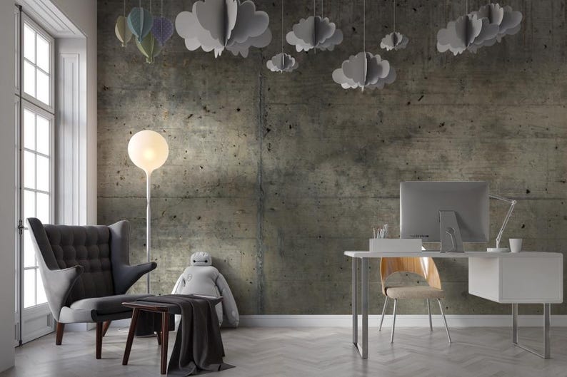 Peut inclure: Int&eacute;rieur de bureau moderne avec un mur en b&eacute;ton. Un fauteuil gris, une petite table en bois et un bureau avec un &eacute;cran d'ordinateur sont visibles. Des d&eacute;corations en forme de nuages et de ballons sont suspendues au plafond.