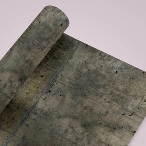 Peut inclure: Une feuille de papier roul&eacute;e avec une texture de b&eacute;ton gris. Le papier a un aspect vieilli avec des taches sombres et une fissure visible. Le fond est rose p&acirc;le.