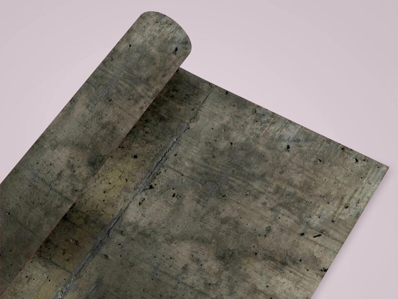 Peut inclure: Une feuille de papier roul&eacute;e avec une texture de b&eacute;ton gris. Le papier a un aspect vieilli avec des taches sombres et une fissure visible. Le fond est rose p&acirc;le.