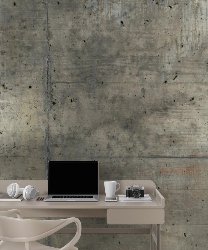 Peut inclure: Un bureau aux tons neutres avec un ordinateur portable, un casque, une tasse, un smartphone et un appareil photo vintage. Le bureau est plac&eacute; contre un mur en b&eacute;ton textur&eacute;. Une chaise blanche est devant le bureau.