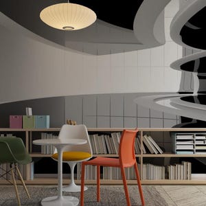 May include: A modern interior design featuring a black and white mural with curved architectural elements. The room includes a bookshelf, a small round table, and colorful chairs. A pendant light and a floor lamp illuminate the space.