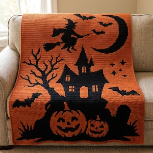 Könnte beinhalten: Eine rechteckige Häkeldecke mit einem Halloween-Motiv in Orange und Schwarz. Das Muster zeigt die schwarze Silhouette eines Spukhauses, eine Hexe auf einem Besen, eine Mondsichel, Fledermäuse und zwei geschnitzte Kürbisse mit grinsenden Gesichtern.