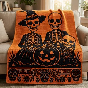 May include: A rectangular crochet blanket featuring a vibrant orange background with a black graphic design of two adult skeletons and one child skeleton. The adult on the left wears a witch hat. A large jack-o'-lantern sits in the center.