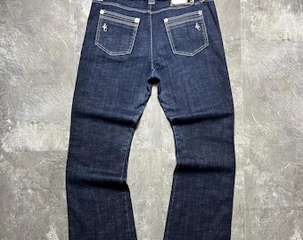 Jeans vintage Versace Couture in denim indaco scuro, Made in Italy, placca con logo Medusa Y2K, cuciture bianche a contrasto, modello bootcut, taglia 33 Ittie