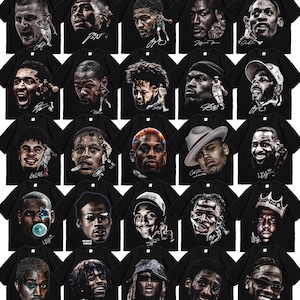 May include: A collection of twenty-five black t-shirts, each featuring a distinct graphic print of a famous athlete or celebrity portrait. The designs include realistic facial illustrations, player action shots, and stylized signatures on the front.