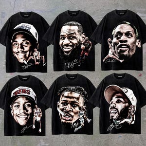 May include: Six black t-shirts featuring portraits of basketball players. Each shirt displays a different player's face, signature, and a small action shot. The shirts are a dark, faded black.
