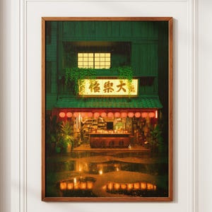 Può includere: Stampa incorniciata di un ristorante giapponese di notte. L'edificio verde ha una tenda da sole rossa e lanterne luminose. L'insegna del ristorante mostra caratteri giapponesi. Riflessi delle luci nelle pozzanghere sul terreno.