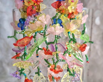 Pendientes largos colgantes adornados con pequeñas, múltiples y hermosas flores multicolores en cascada, de un elegante y original estilo bohemio.