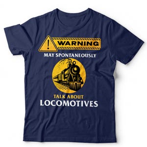 May include: A navy blue short-sleeve t-shirt featuring a yellow warning sign graphic with the text WARNING MAY SPONTANEOUSLY TALK ABOUT LOCOMOTIVES and a black illustration of a steam train inside a yellow circle on the front centre.