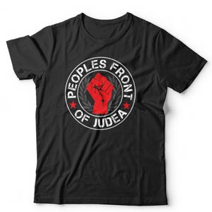 May include: A black short-sleeved t-shirt featuring a circular graphic on the chest. The design includes a red raised fist in the centre, surrounded by a laurel wreath and the text "PEOPLES FRONT OF JUDEA" with two small red stars.