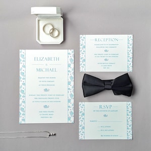 May include: Wedding invitation suite with a blue and white seashell pattern. The invitation card features the names Elizabeth and Michael, the date and time of the wedding, and the location. The reception card includes the date, time, and location of the reception. The RSVP card includes a space for guests to indicate whether they will attend and the number of guests.