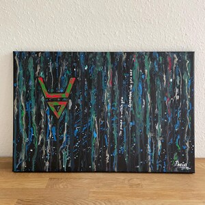 May include: Abstract art canvas with a black background and vertical streaks of blue, green, and white paint. A red and green geometric symbol is centered on the left. The text "The power is within you. Remember who you are" is written on the right.