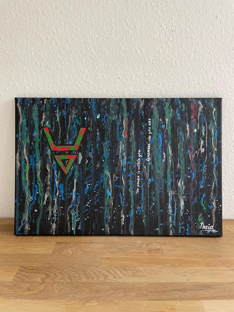 May include: Abstract art canvas with a black background and vertical streaks of blue, green, and white paint. A red and green geometric symbol is centered on the left. The text "The power is within you. Remember who you are" is written on the right.