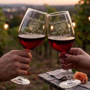 Könnte beinhalten: Zwei Weingläser aus klarem Glas gefüllt mit Rotwein, jeweils graviert mit dem Text Rubinhochzeit, einem herzförmigen Diamantsymbol mit der Zahl 40, den Jahren 1984 und 2024 sowie den Namen Irena & Robert in weißer Schreibschrift.