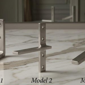 May include: Three brushed metal shelf brackets, each with a different design. Model 1 is an L-shape, Model 2 has a horizontal support, and Model 3 is angled. Each bracket has pre-drilled holes for mounting. The text "Model 1", "Model 2", and "Model 3" are below each bracket.