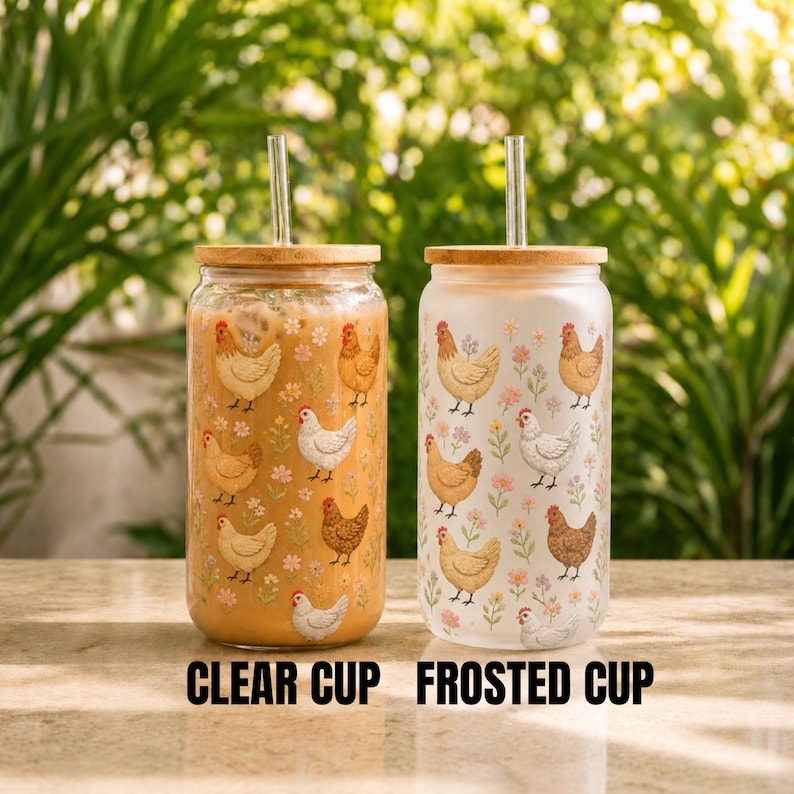 Puede incluir: Dos vasos de vidrio con tapas de bamb&uacute; y pajitas de metal. Uno es transparente, el otro esmerilado. Ambos presentan un patr&oacute;n repetido de gallinas y flores. El texto "CLEAR CUP" y "FROSTED CUP" est&aacute; impreso debajo.