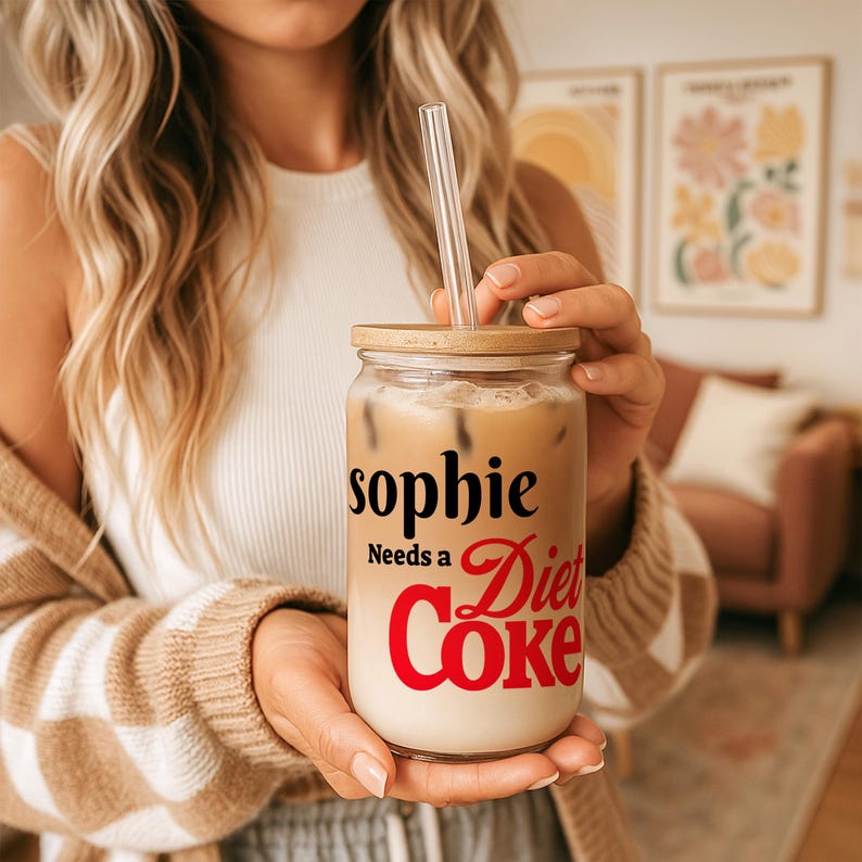 May include: A clear glass tumbler with a wooden lid and a clear straw, filled with a layered beverage. The tumbler has the text "sophie Needs a Diet Coke" in black and red lettering.