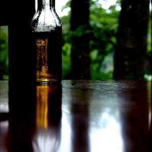 Moody Beer Bottle Photography Print | Rustic Cabin Wall Art | Dark Aesthetic Nature Photo | Bar Decor | Cinematic Reflection Art