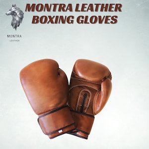 May include: Brown leather boxing gloves with black wrist straps. The gloves are displayed against a light background. The text "MONTRA LEATHER BOXING GLOVES" is at the top of the image, with the Montra Leather logo in the upper left corner.