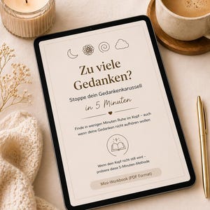 Könnte beinhalten: Ein digitales Tablet zeigt deutschen Text: "Zu viele Gedanken?" (Zu viele Gedanken?) und "Stoppe dein Gedankenkarussell in 5 Minuten" (Stoppen Sie Ihr Gedankenkarussell in 5 Minuten). Eine brennende Kerze, eine Kaffeetasse und ein goldener Stift sind ebenfalls zu sehen.