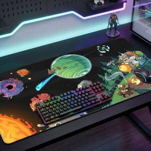 Pode incluir: Um tapete de rato para jogos preto com um design colorido com tema espacial. O tapete apresenta um teclado, um rato e uma ilustração de desenhos animados de planetas, estrelas e personagens. O teclado tem iluminação RGB.