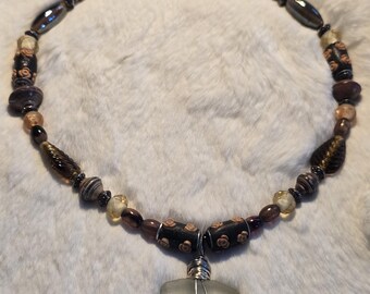 Collar de cuentas con colgante de piedra engarzada en alambre.