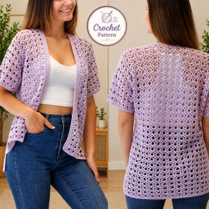 May include: A light purple, open-weave crochet cardigan with short sleeves. The cardigan is worn over a white top and blue jeans. The image also includes a circular logo with the words "Crochet Pattern".