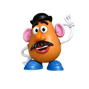 Puede incluir: Una figura de juguete marrón con forma de patata, con un bombín negro, ojos blancos, una nariz naranja grande, un bigote negro y labios rojos. La figura tiene orejas rosas, brazos blancos con guantes blancos y zapatos azules.
