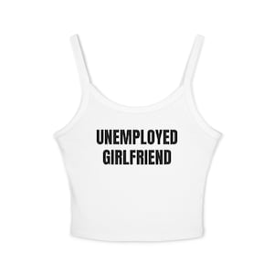 Könnte beinhalten: Ein weißes ärmelloses bauchfreies Oberteil mit dünnen Trägern und einem Rundhalsausschnitt. Der Text UNEMPLOYED GIRLFRIEND ist in fetten, schwarzen, serifenlosen Großbuchstaben mittig auf der Brust des Kleidungsstücks aufgedruckt.