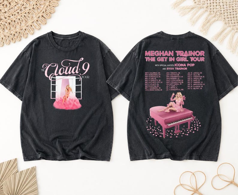 May include: Black t-shirts featuring a pink graphic of a woman on a piano and the text "MEGHAN TRAINOR THE GET IN GIRL TOUR". The front of the shirt has the text "Cloud 9 TOUR" with a pink graphic.