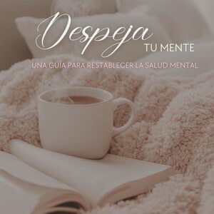 Puede incluir: Una taza blanca con una bebida caliente descansa sobre un libro abierto, con el texto en español "Despeja tu mente" (Despeja tu mente). La imagen está ambientada sobre una manta suave y texturizada, sugiriendo un ambiente acogedor y relajante.
