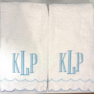 May include: Two white rectangular terry cloth towels featuring a scalloped bottom edge trimmed in light blue thread. Each towel is embroidered with the monogram KLP in a light blue serif font centered above the decorative scalloped border.