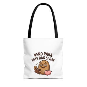 Könnte beinhalten: Weiße Tragetasche mit schwarzen Henkeln. Das Design zeigt eine Cartoon-Kartoffel mit leerem Portemonnaie und einem kleinen rosa Schwein. Der Text lautet "PERO PARA TOTE BAG SI HAY".