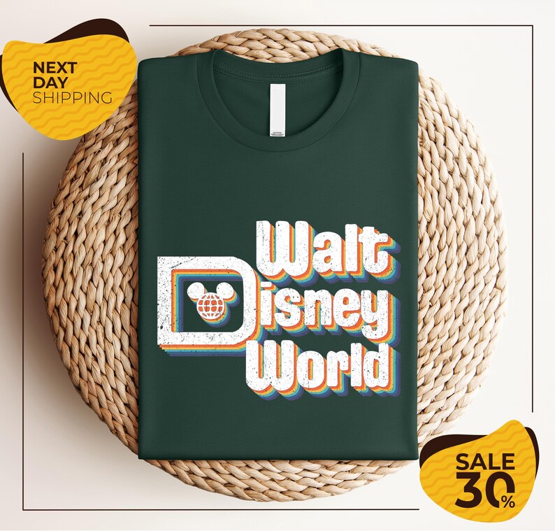 A green t-shirt with the text "Walt Disney World" printed on it, displayed on a woven basket.