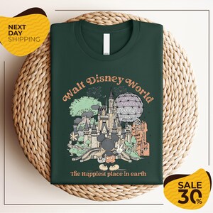 A green t-shirt with a graphic design of various Disney landmarks and the text "Walt Disney World" printed on it, placed on a woven basket.