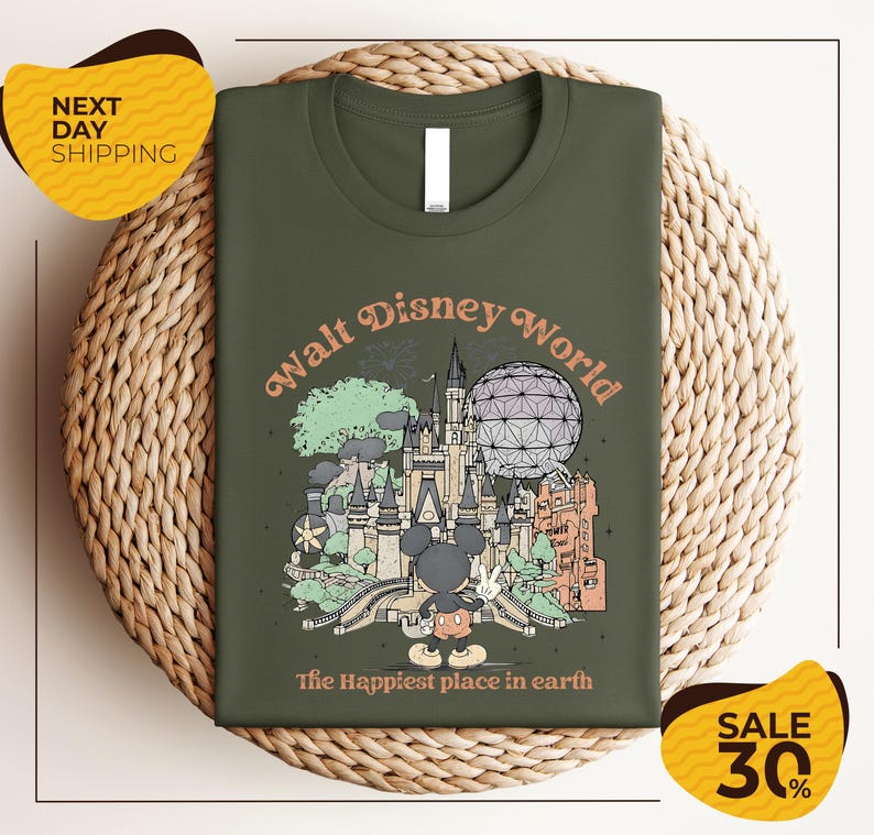 A green t-shirt with a graphic design of various Disney landmarks and characters, including Mickey Mouse, the Eiffel Tower, and the Space Needle, along with the text "Walt Disney World" and "The Happiest place in earth".