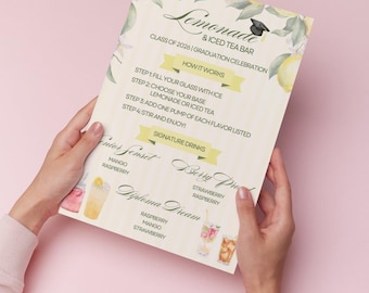 Pode incluir: Um menu de bar de limonada e chá gelado com tema de formatura, segurado por mãos contra um fundo rosa. O menu apresenta um design floral, receitas de bebidas e o texto "Turma de 2026 | Celebração de formatura".