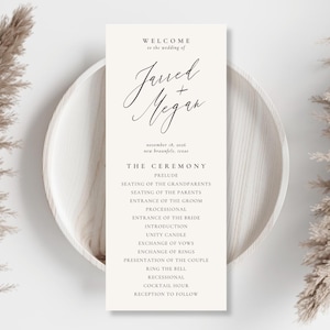 May include: A vertical cream-colored wedding program card featuring black text that reads Welcome to the wedding of Jarred + Megan, November 18, 2016, New Braunfels, Texas, followed by a detailed list of ceremony events from Prelude to Reception.