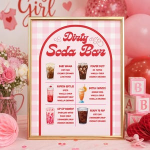 May include: A framed sign with a pink and white checkered background, advertising a "Dirty Soda Bar" with various drink recipes. The sign is decorated with pink hearts and balloons, perfect for a baby shower.