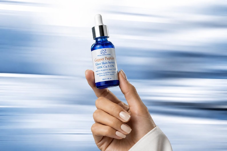 K&ouml;nnte beinhalten: Eine kleine blaue Glastropfflasche mit Copper Peptide Glass Skin Serum GHK-Cu 3.33% und einem wei&szlig;en Tropfverschluss. Das Etikett tr&auml;gt den Text Copper Peptide Glass Skin Serum GHK-Cu 3.33% und gibt ein Volumen von 30 ml an.