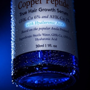 May include: A cylindrical bottle of Precise Formulations Copper Peptide True Hair Growth Serum with GHK-Cu 6% and AHK-Cu 1% with Hyaluronic Acid. The label lists ingredients as Sterile Water, GHK-Cu, AHK-Cu, Hyaluronic Acid. Volume is 30ml | 1fl. oz.