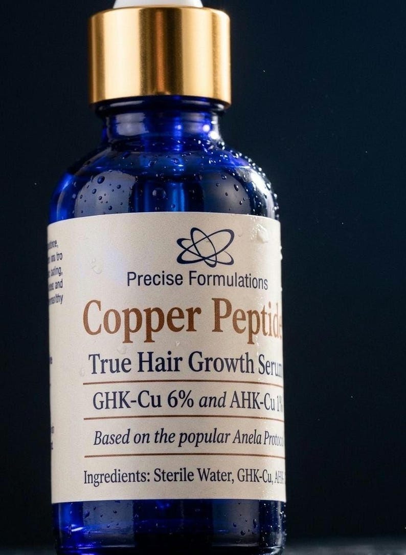 May include: A blue glass dropper bottle with a gold cap containing Copper Peptide True Hair Growth Serum. The label features the text Precise Formulations, GHK-Cu 6% and AHK-Cu 1%, and lists ingredients including Sterile Water, GHK-Cu, and AHK-Cu.