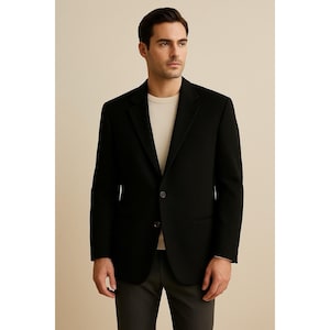 Könnte beinhalten: Ein schwarzer Blazer mit Zwei-Knopf-Verschluss, fallendem Revers und Brusttasche. Der Blazer wird mit einem hellfarbigen Rundhals-Shirt und einer dunkelgrauen Hose kombiniert. Geeignet für formelle oder geschäftliche Anlässe.