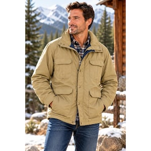 May include: A tan utility jacket featuring a high collar, a full-length front zipper, and a snap-button placket. The jacket includes two chest pockets with flaps and two lower patch pockets with flaps, worn over a plaid button-down shirt and blue jeans.