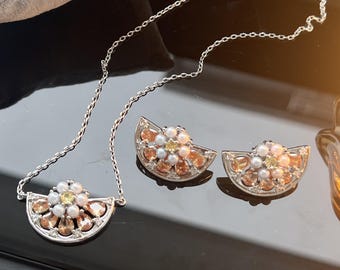 Conjunto de joyas vintage de perlas en forma de media luna, collar y pendientes, un símbolo de estilo clásico y elegante.